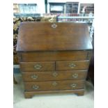 Oak bureau with drawers under and brass handles. Inside is a hidden sliding compartment along with