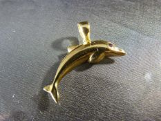 An 18ct Yellow Gold Dolphin pendant set with a small Ruby stone for the Eye.The chunky Bale is