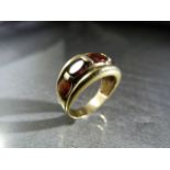 Unmarked Gold ring approx 11mm wide and set with 5 graduated Oval Garnet stones. Size approx UK -