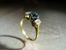 18ct Yellow Gold ring set with Central Bright Blue Topaz and flanked by 3 small diamond chips either