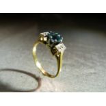 18ct Yellow Gold ring set with Central Bright Blue Topaz and flanked by 3 small diamond chips either