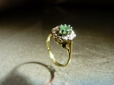 9ct Gold Emerald and Diamond Cluster Dress ring. The Oval approx 5.4mm x 3.9mm wide emerald is