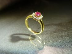 18ct Yellow Gold starburst style ring set with Central ruby and Surrounded by 12 small diamonds on a
