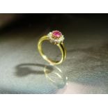 18ct Yellow Gold starburst style ring set with Central ruby and Surrounded by 12 small diamonds on a
