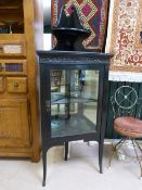 Black lacquered corner cabinet with mirrored back to shelves, over sits a singular corner shelf