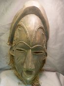 African carved mask with copper rope twist wire decoration inset to eyes, ears and forehead. Slitted
