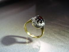18ct Yellow Gold Garnet and Diamond cluster ring in a round setting. Marked 18ct to shank. Ring size