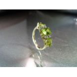 9ct Gold Peridot and Diamond Dress ring. Central oval stone approx 7.08mm x 5.08mm across with a 4.