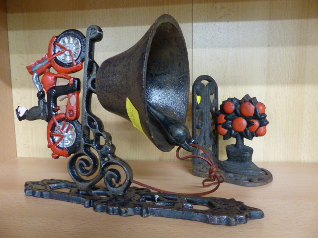 Cast iron hanging doorbell of a man on a bike and a similar cast iron doorstop