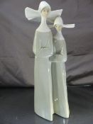Lladro figure group of two nuns, printed marks to base approx 33cm high. Chip to one nuns Coif. A/F