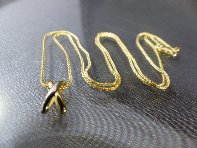 9ct Gold chain approx 18" long with an unmarked 'x' pendant. Total approx weight - 2.9g
