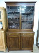 Mahogany 19th century bookcase with cupboards under, shaped frieze decoration sits above two