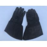 A pair of leather motorcycle gauntlets.