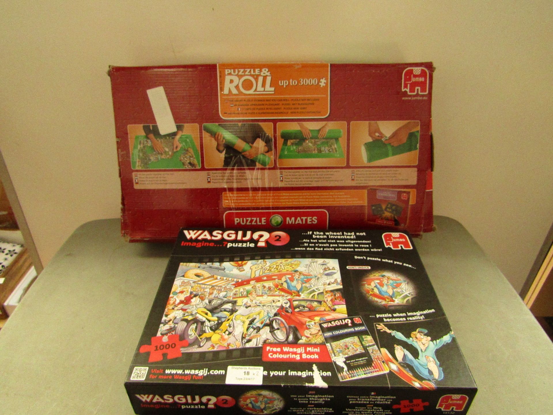 2x Puzzle sets being; Wasgij 1000pc set and Puzzle & roll storage mat. Both unchecked and boxed.