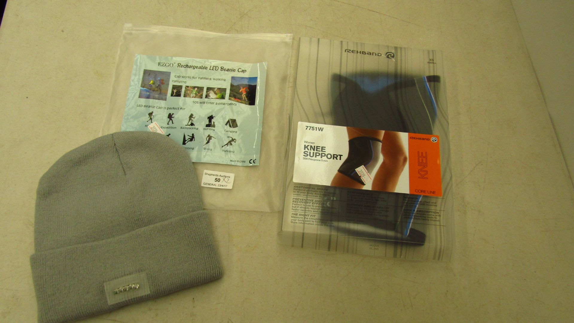 EZGO Rechargeable LED beanie cap and Rehband womens knee support, both unchecked in packaging.