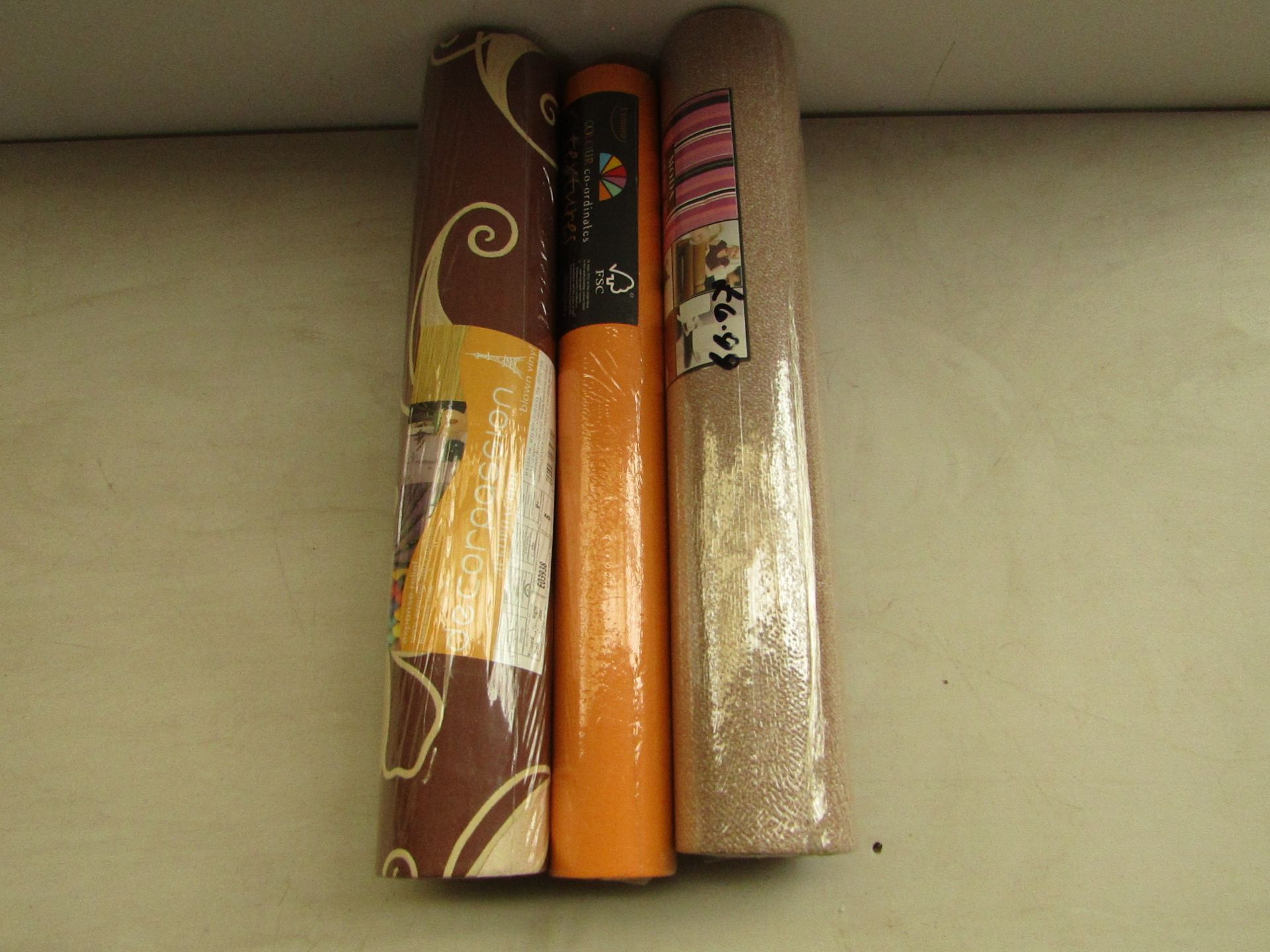Box of 7x various rolls of wallpaper with brands such as Moda and Vymura.