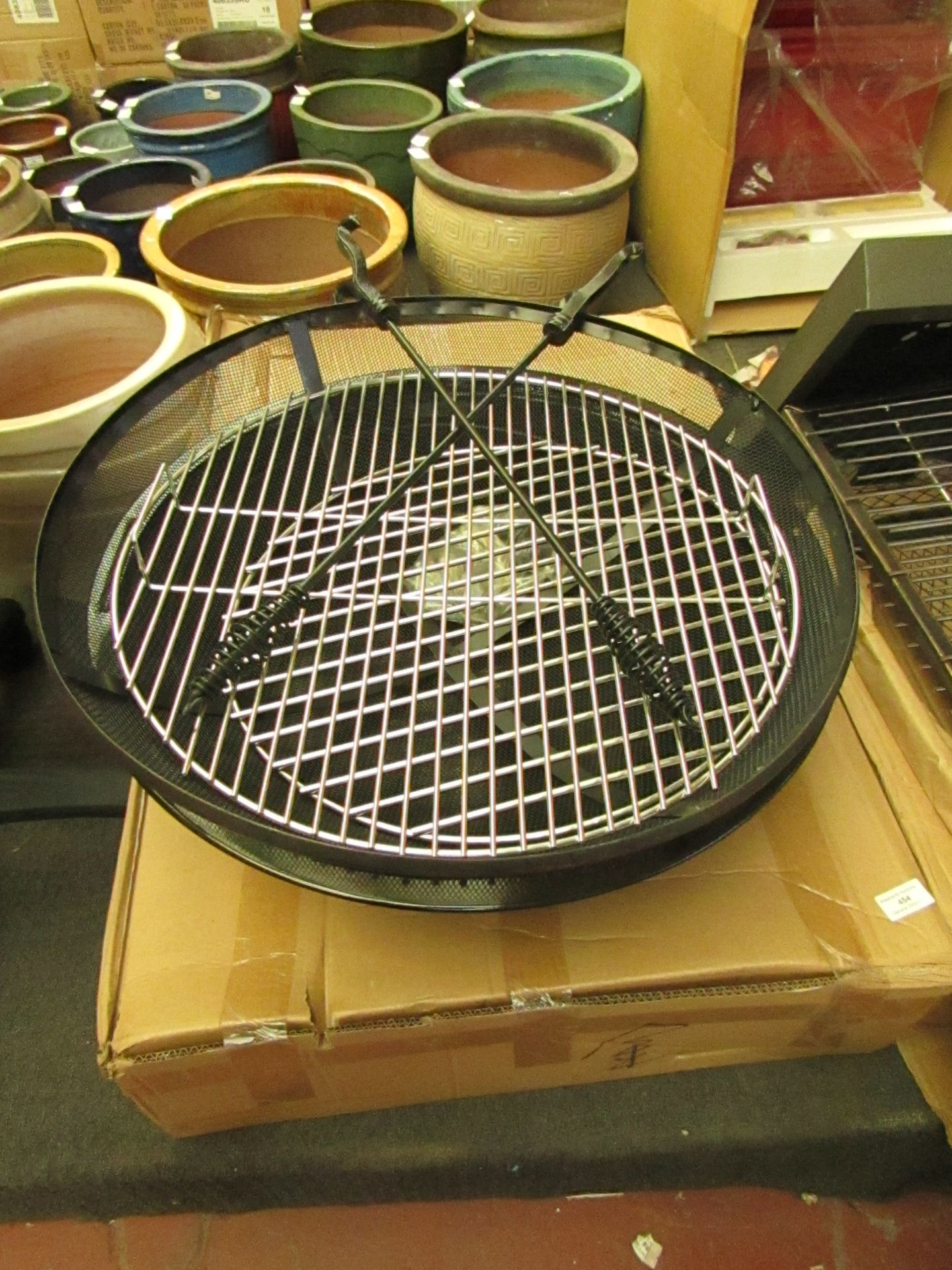 Circular fire pit, 24.5" diameter, comes with various fixings and 2x pokers. Boxed.