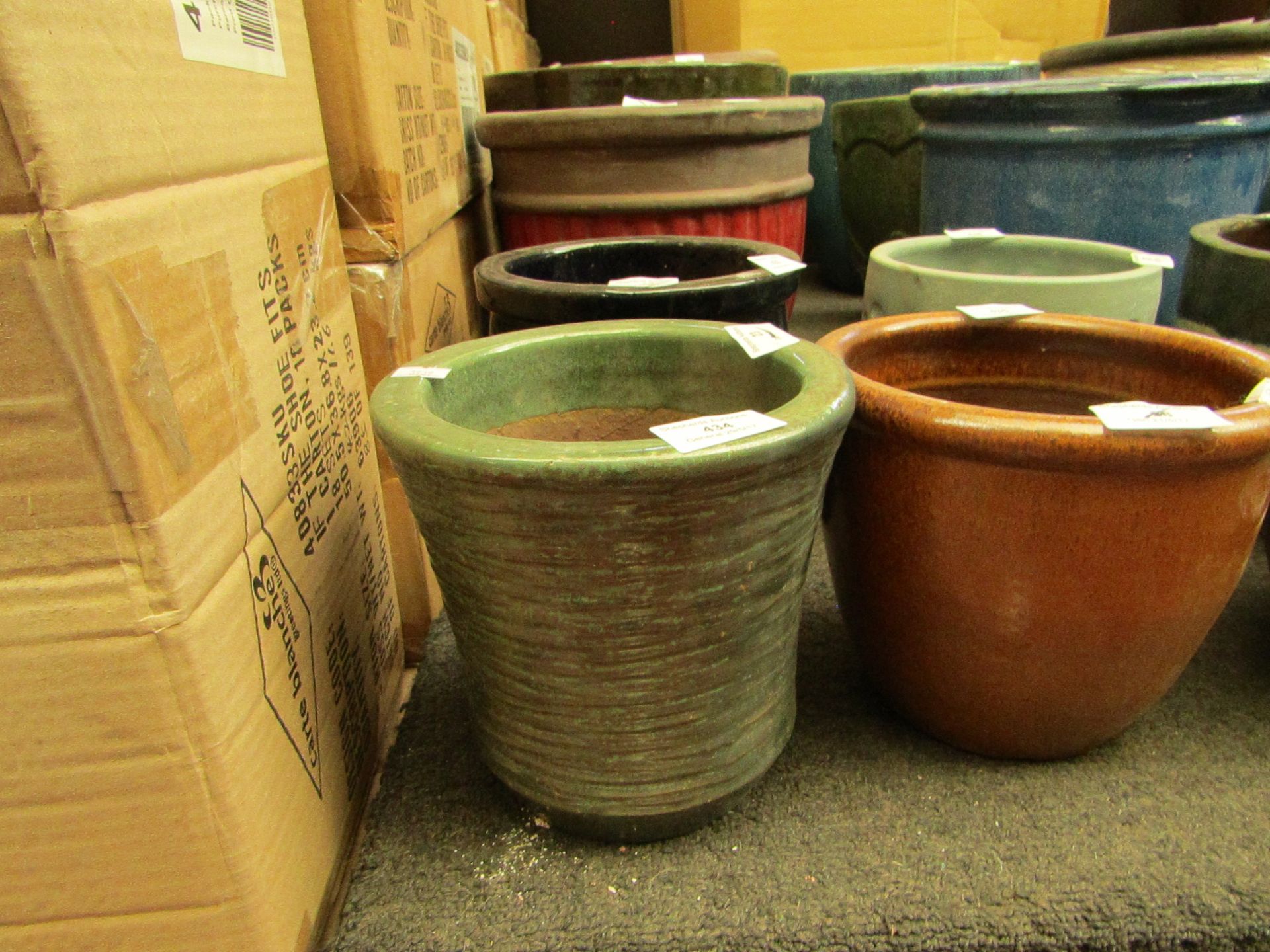 Ceramic style plant pot, green colour 7" tall and 18cm diameter.