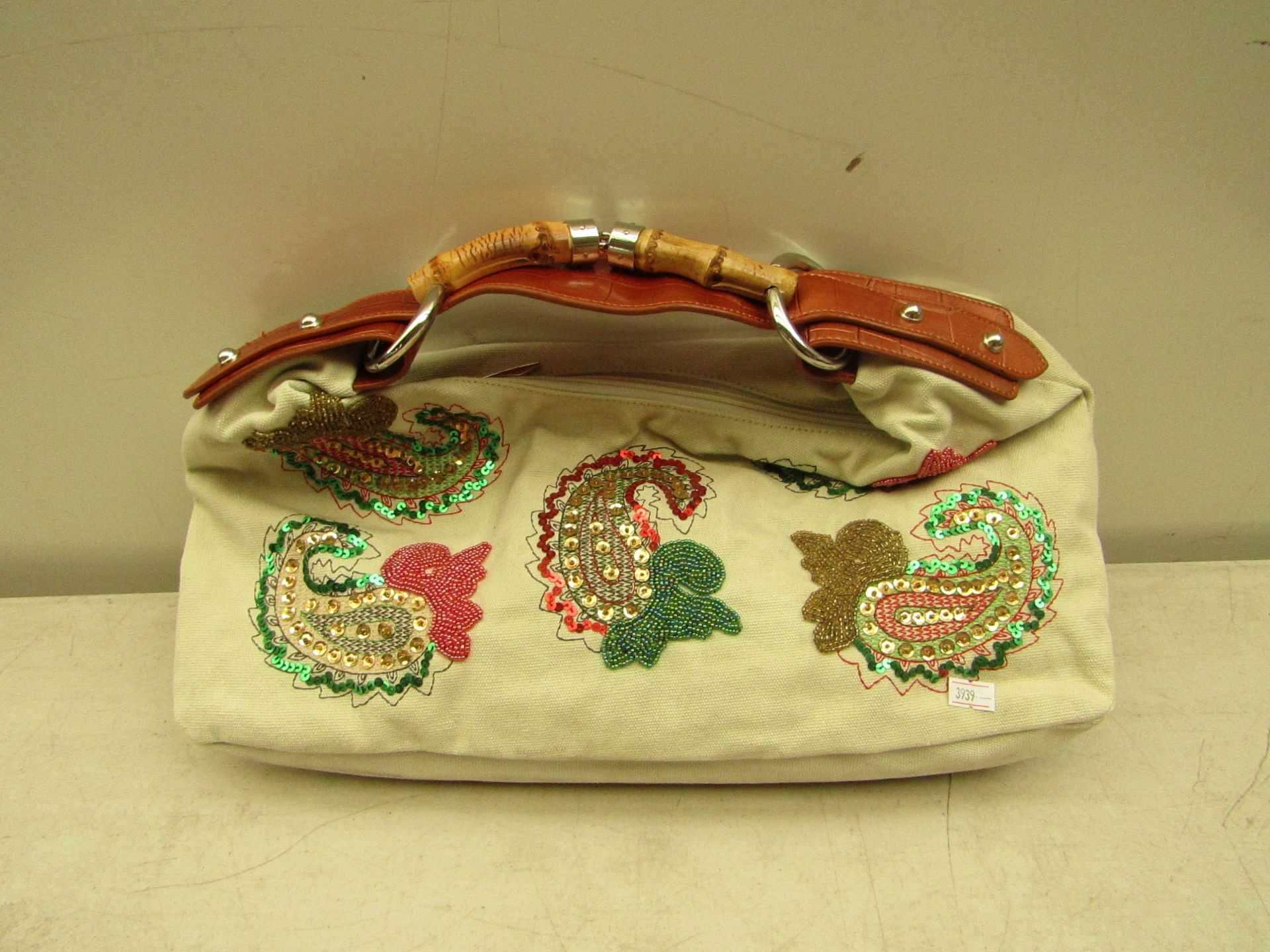 Ivory coloured handbag with sequin patterns, new and packaged.