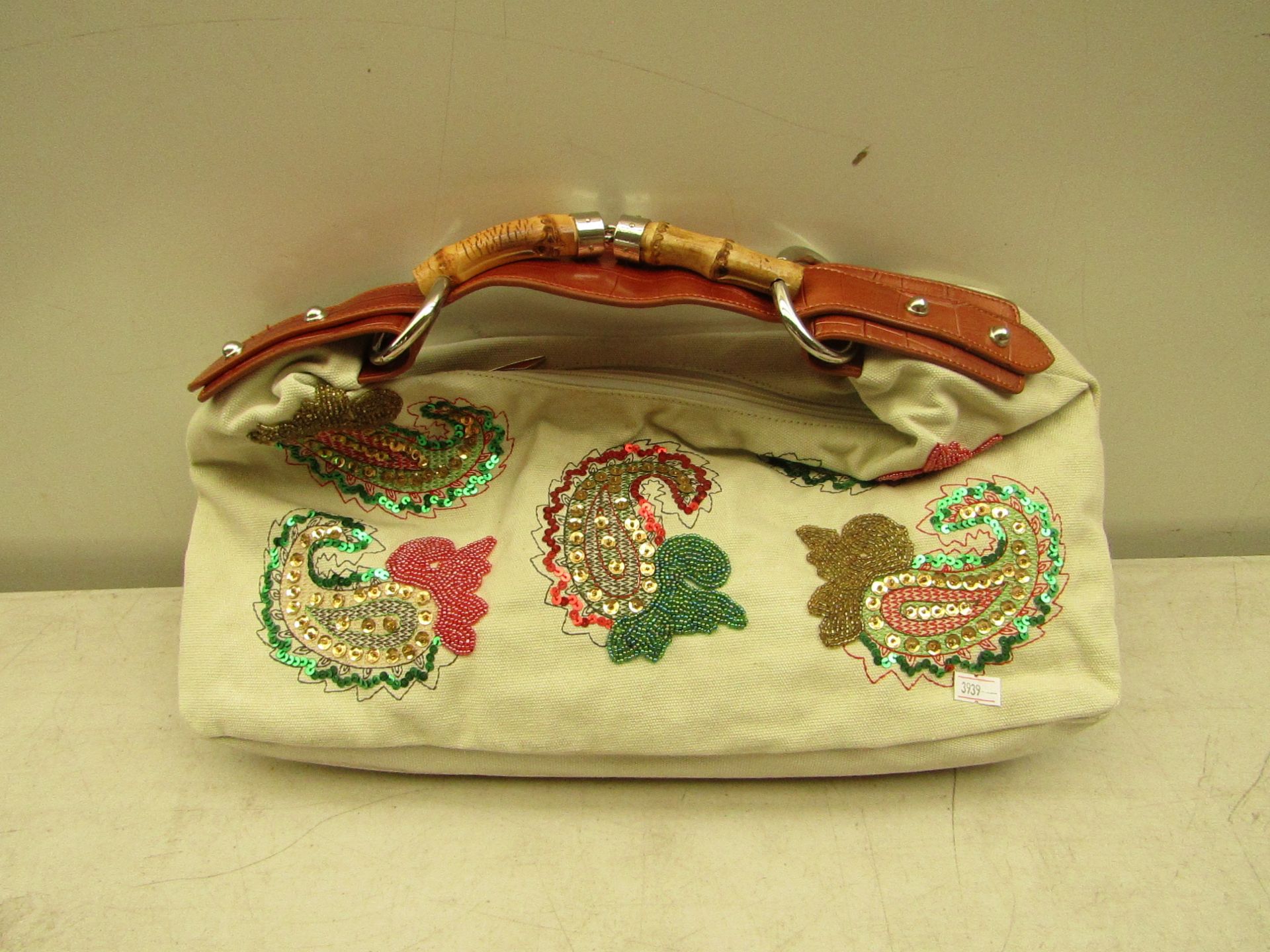 Ivory coloured handbag with sequin patterns, new and packaged.