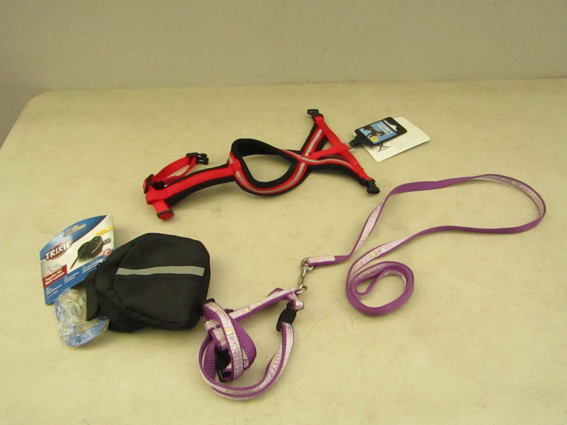 3x items being: - 2x various dog leads (purple and red) - Trixie medium to large bag for retractable