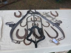 Quantity of old horseshoes, a pair of hames, a saddle rack and a horse bit with players