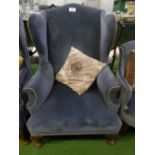 Blue velour-type upholstered wing back chair on pad feet