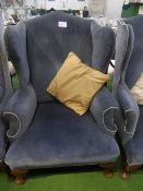 Blue velour-type upholstered wing back chair on carved legs & pad feet