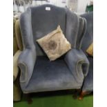 Blue velour-type upholstered wing back chair on carved legs & pad feet