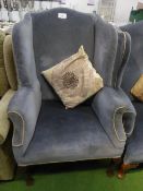 Blue velour-type upholstered wing back chair on carved legs & pad feet