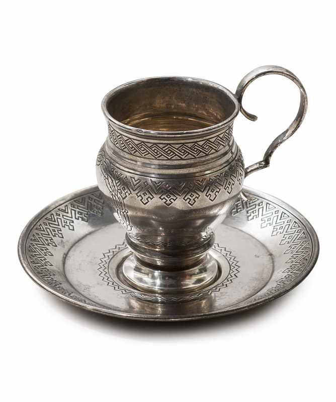 Silber - - Tasse mit Untersetzer, je mit graviertem geometrischem Dekor, die Tasse vorn mit leerer