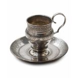 Silber - - Tasse mit Untersetzer, je mit graviertem geometrischem Dekor, die Tasse vorn mit leerer