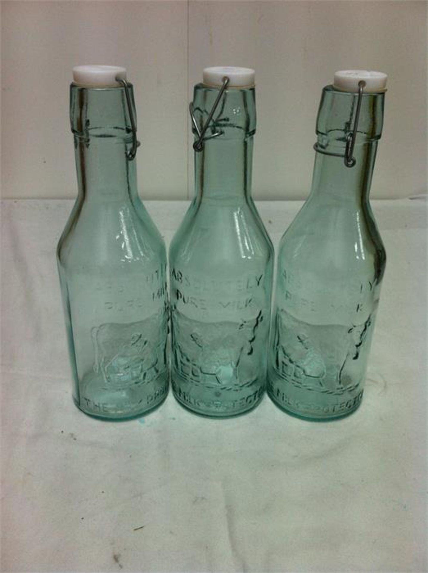 Quantity of 100% recycled glassware; 5 carafes/3 bottles with ceramic tops/4 storage jars/3 candle v