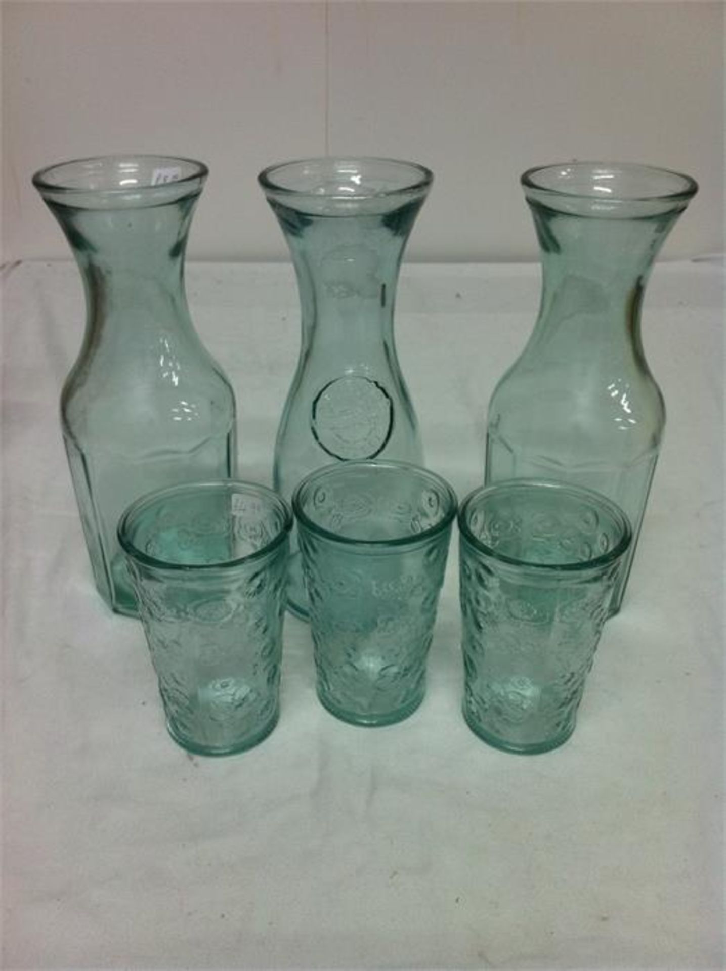 Quantity of 100% recycled glassware; 5 carafes/3 bottles with ceramic tops/4 storage jars/3 candle v