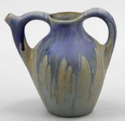 Henkelkrug Keramik, heller Scherben. Laufglasur in blau-ocker. Unter dem Stand eingeritzt: G M