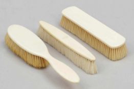 2 Kleiderbüsten und 1 Haarbürste Um 1900. Elfenbein. L. der Kleiderbürsten je 18 cm. L. der