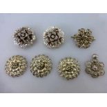 7 filigrane Silberbroschen bzw. Schließen, alle in Blütenform, tlw. min. besch., d. 3,5cm - 4,5cm
