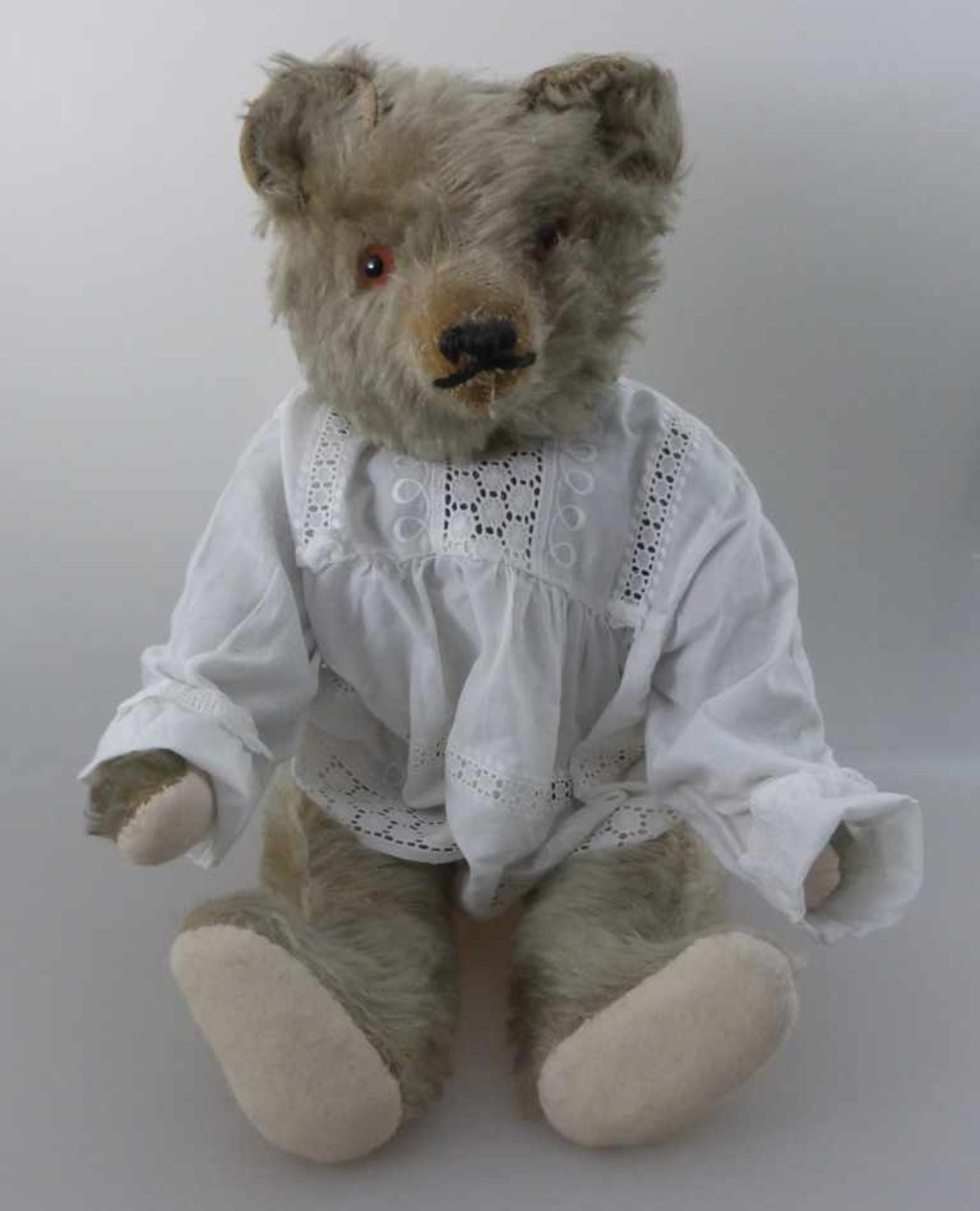 Teddy um 1930, wohl Steiff, Mohair, ausgeprägter Buckel, Tatzen neu genäht, Spielspuren, stehend