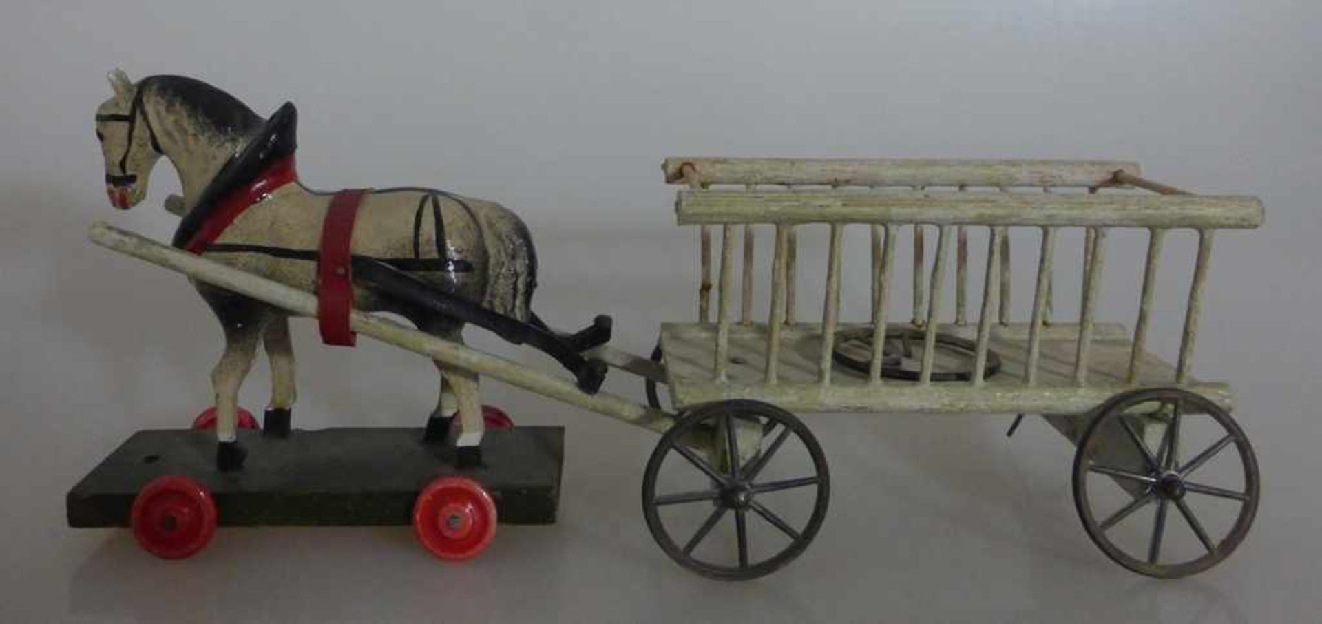 Spielzeugpferd mit Wagen um 1930, Holz, am Wagen ein Rad gebrochen, l. 25cm