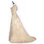 A tamboured lace and silk bridal gown, circa 1900, worked with bows and floral sprigs,