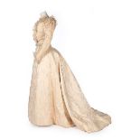An ivory damask silk bridal gown, circa 1890, the bodice adorned with pintucks,