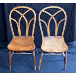 A pair of kitchen chairs with unusual backs