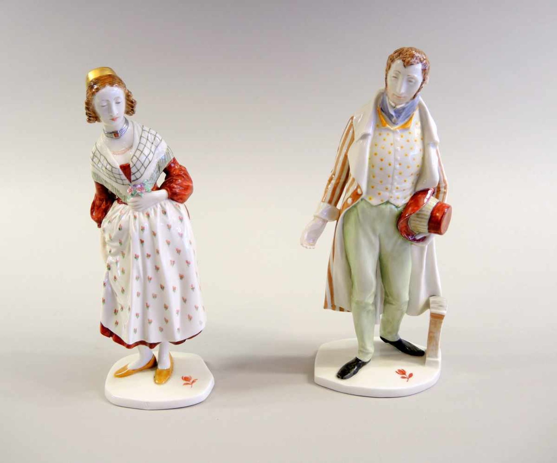 Paar Nymphenburg Figuren Porzellan, polychrom und gold staffiert. Mädchen in Tracht und Herr im