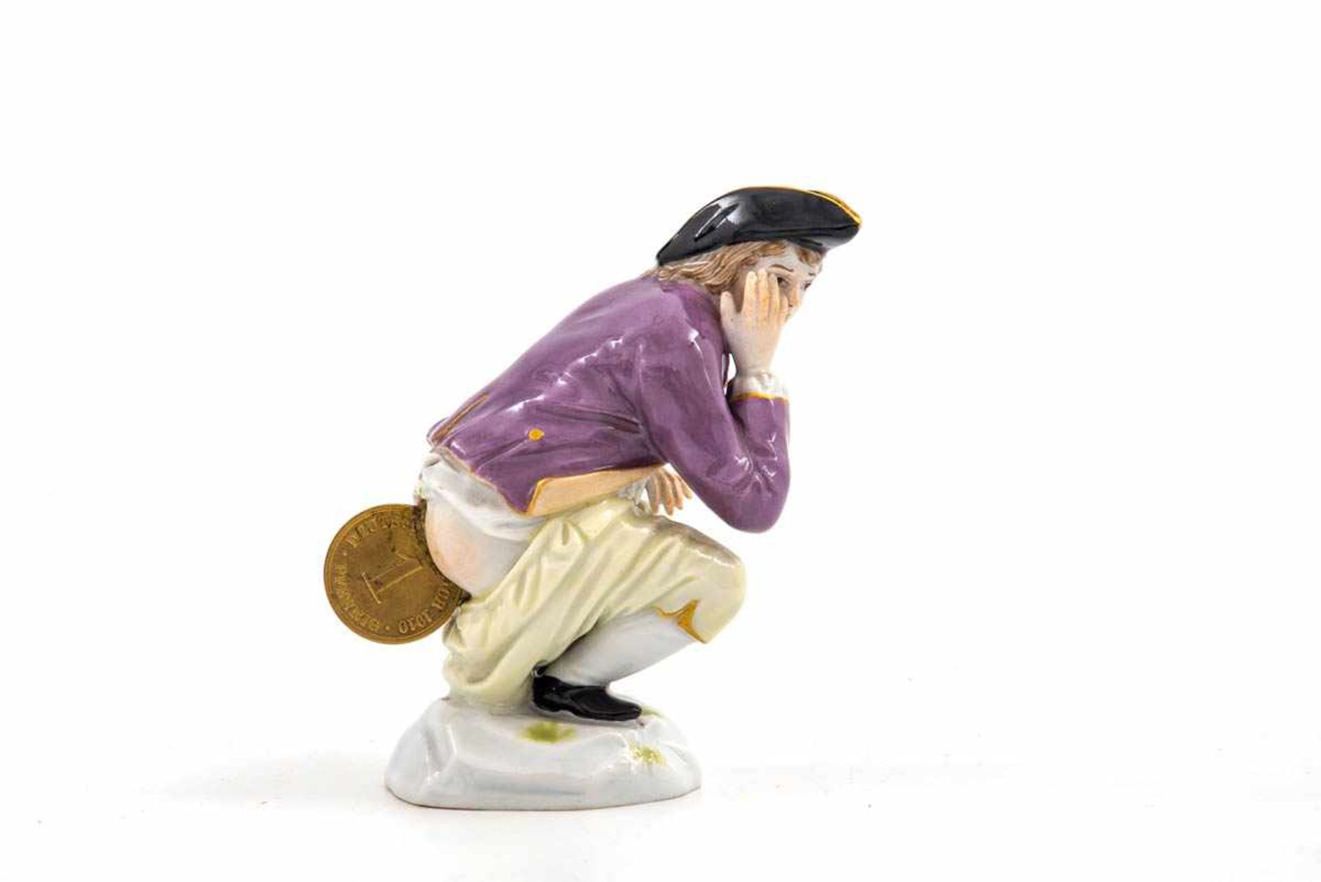 Dukatenkacker, Meissen um 1910 Polychrom bemalt. Auf einem Sockel sitzend wird der Kavalier in