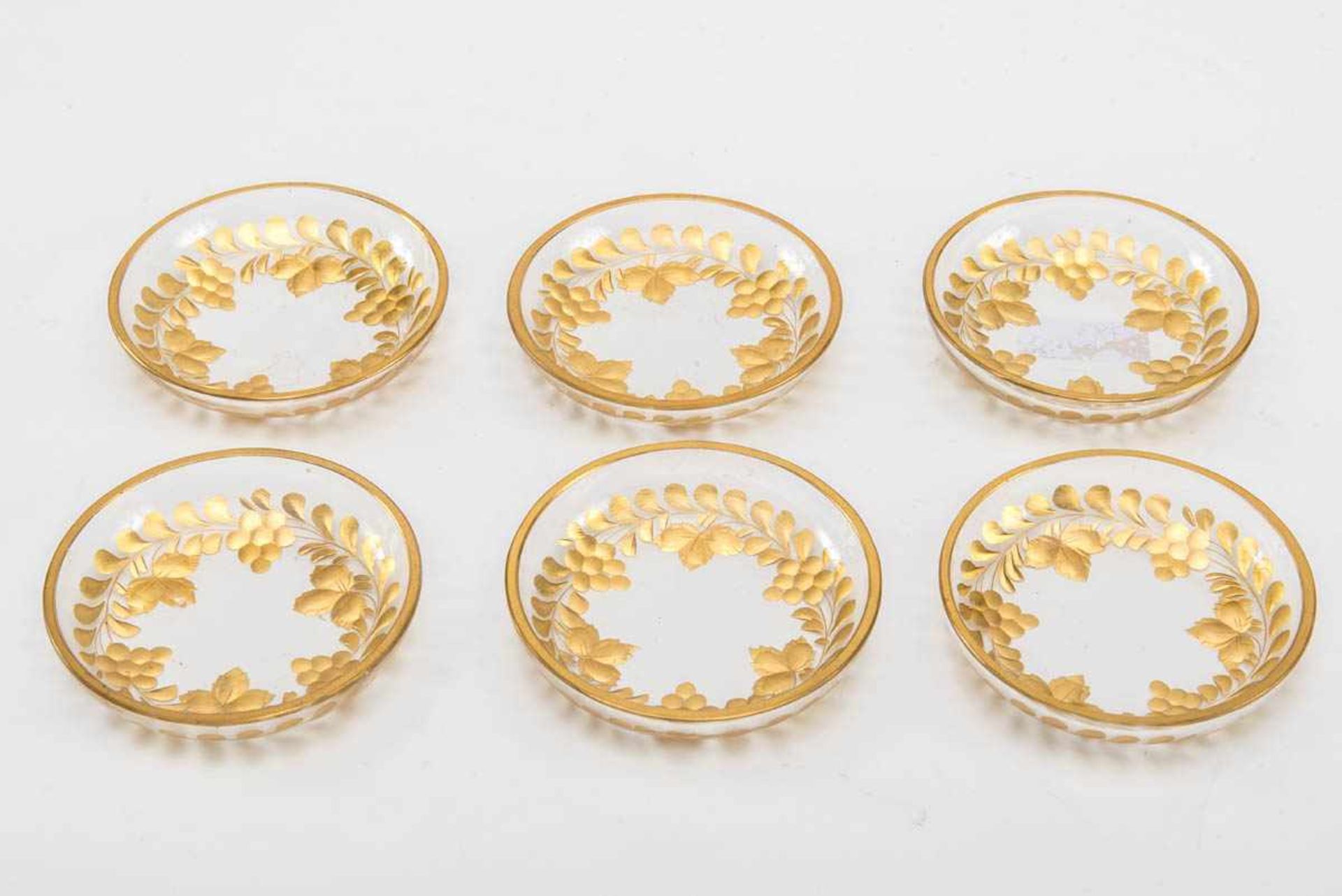 Sechs kleine Teller Farbloses Glas, geschliffen, mit Gold bemalt Runde flachgemuldete Form mit