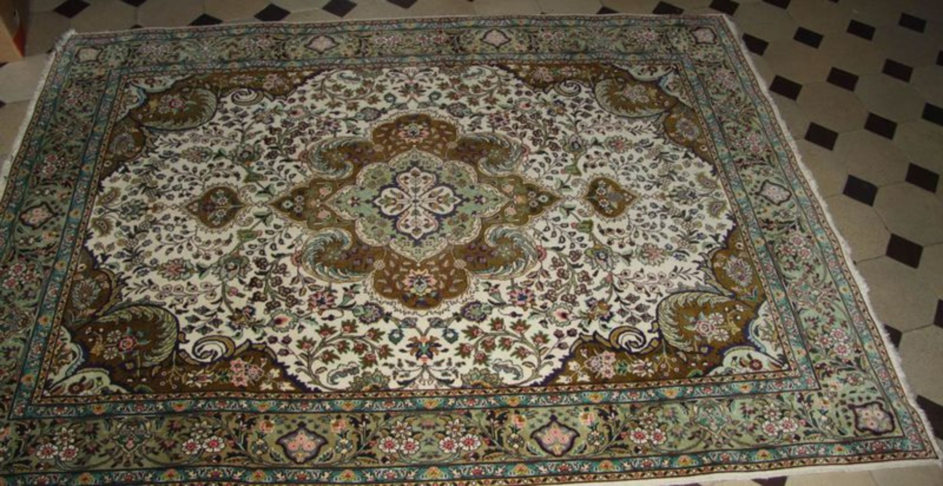 Täbris Teppich Kette und Schuß Baumwolle, Flor Korkwolle. Breite Hauptbordüre mit Blütenranken.