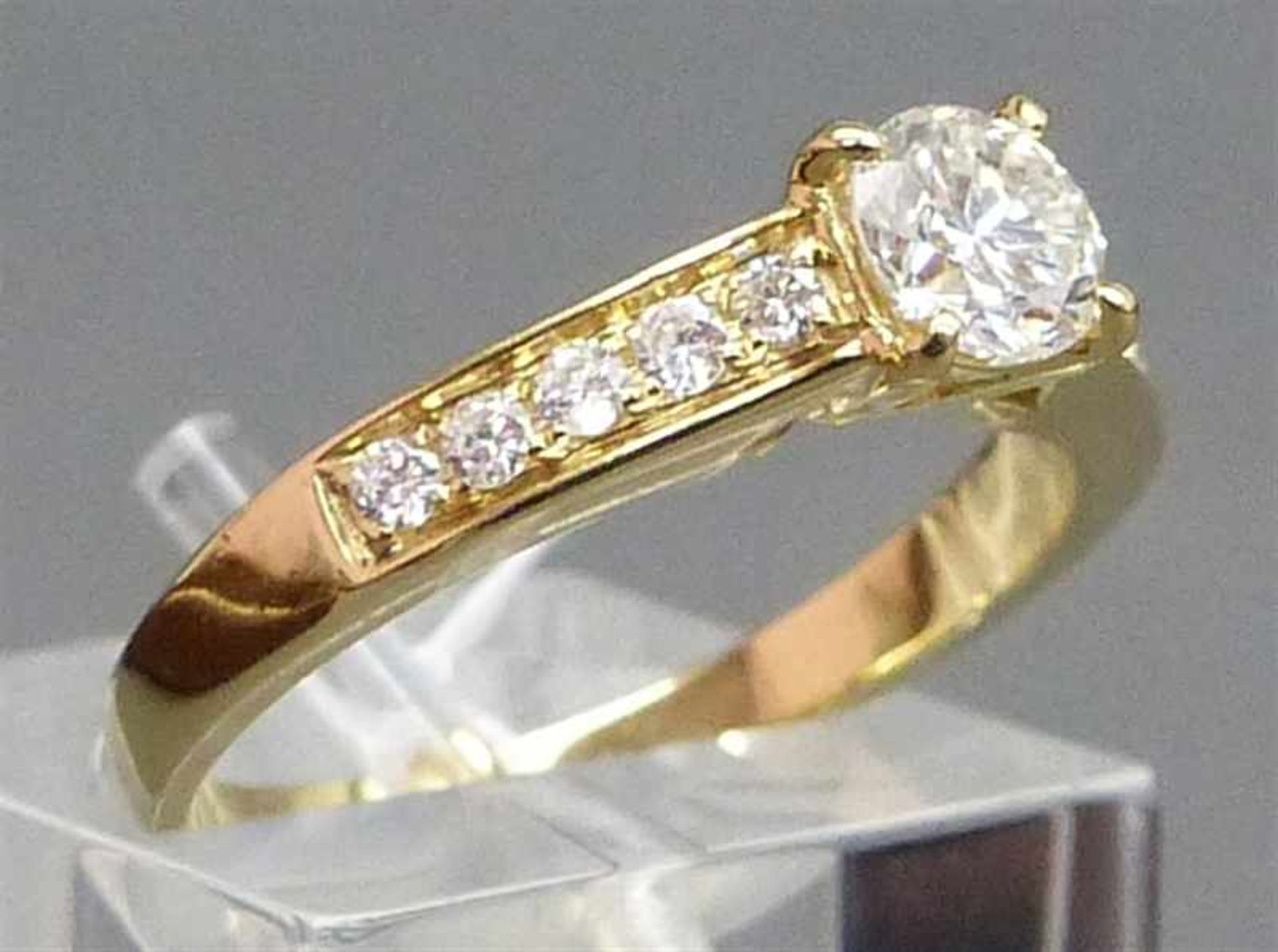 Damenring 14 kt. Gelbgold, 1 Brillant 0,55 ct., getöntes weiß, vsi, 10 Brillanten zus. 0,18 ct.,