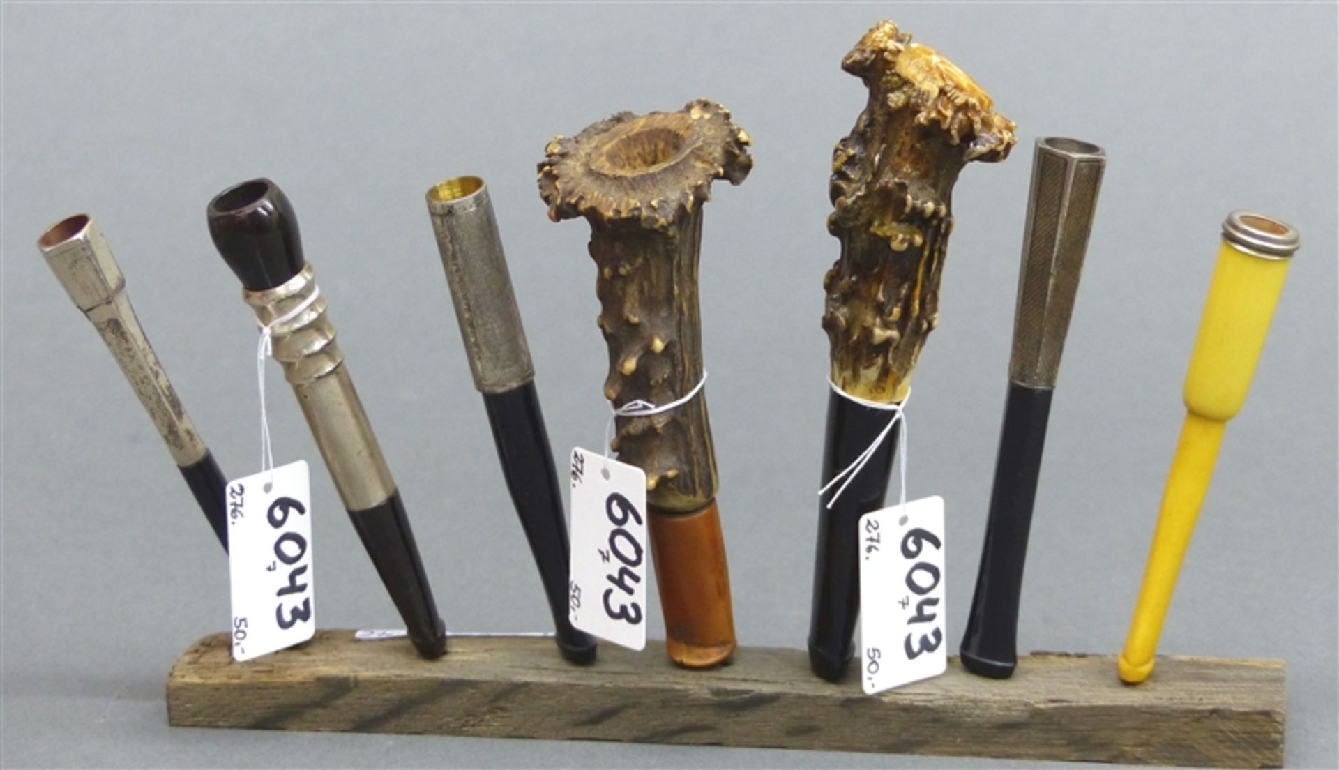 Konvolut Zigarettenspitzen um 1900, 7 St., teilweise Silber, Horn, etc., auf Ständer, h 8-11 cm,