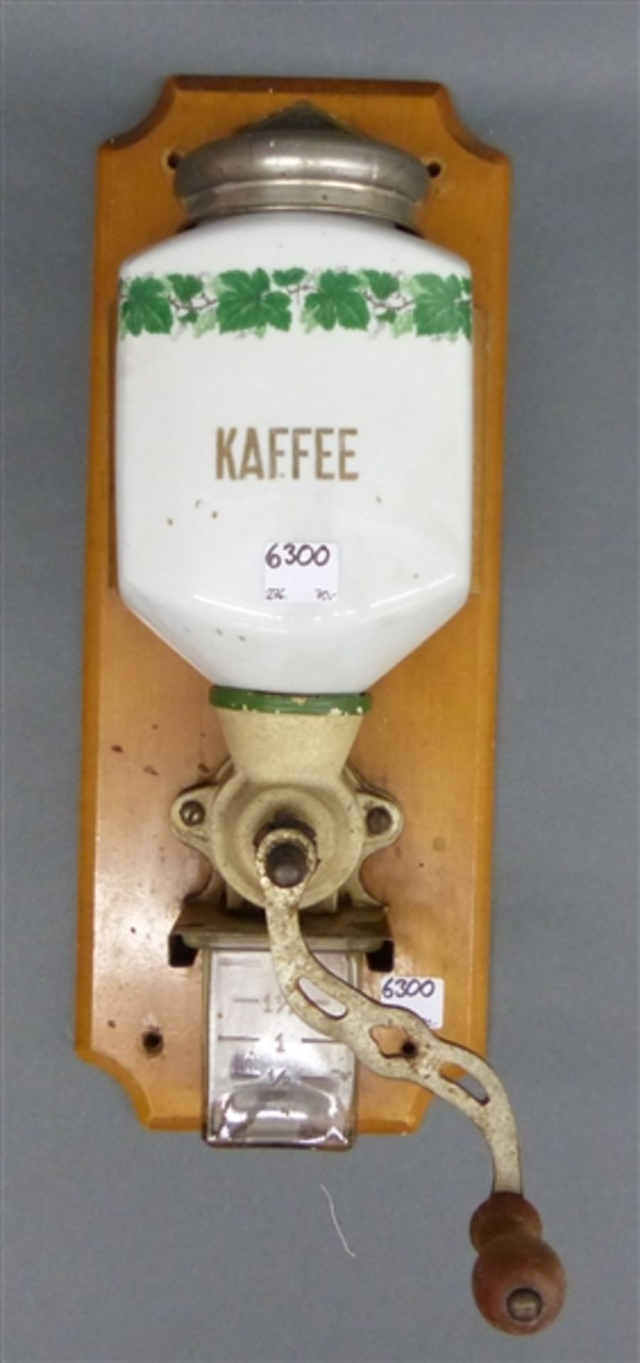 Wandkaffeemühle, 19. Jh. Porzellan, Eisen, mit Glasbehälter, auf Holzbrett, h. (ohne Brett) 33 cm,
