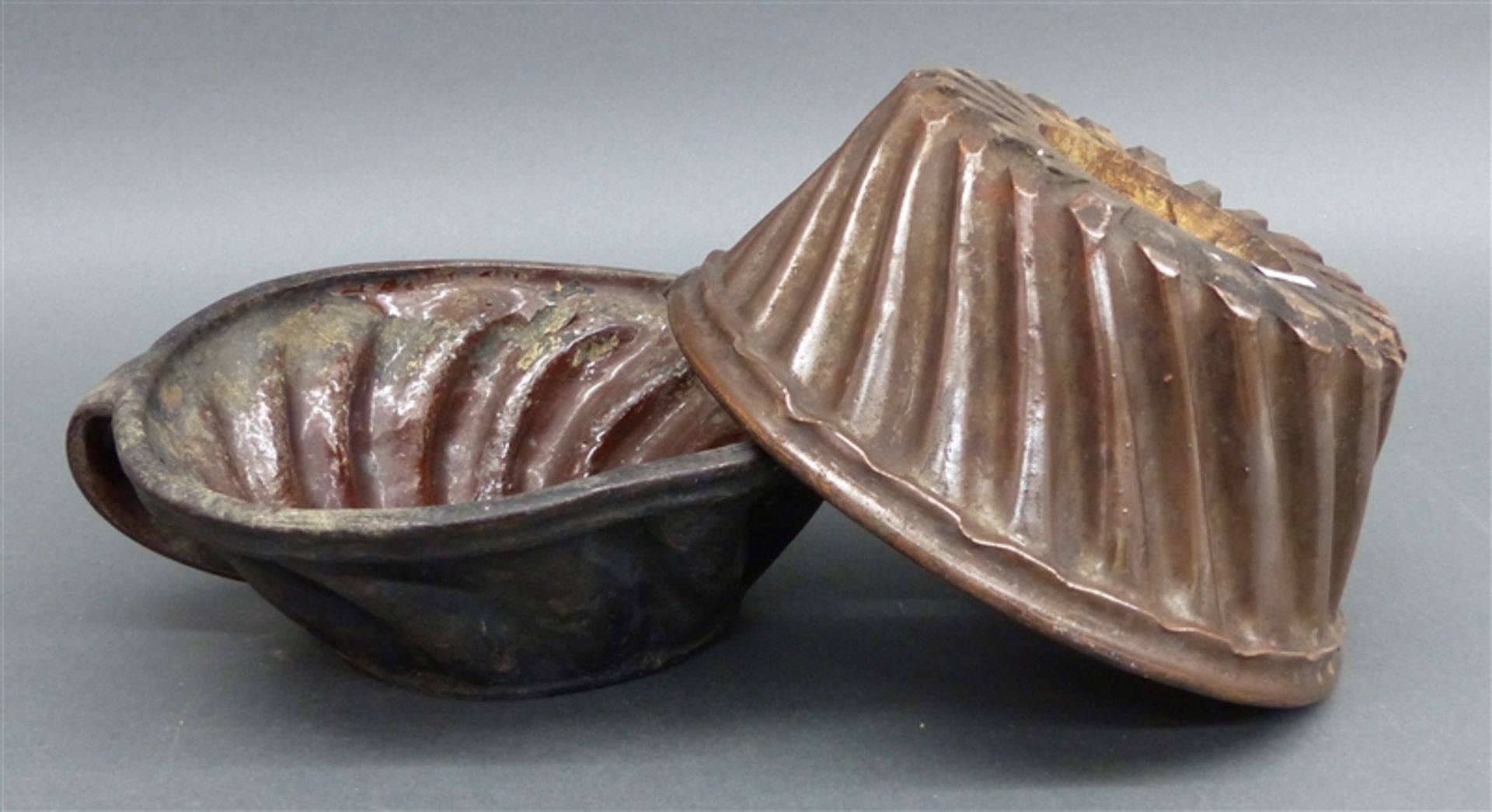 Paar Guglhupfformen Keramik, braune Glasur, beschädigt, 19. Jh., h 8 und 9,5 cm, d 25 und 22,5 cm,